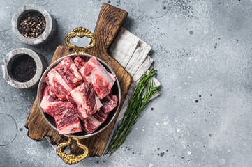 Fresh Raw diced beef  marbled meat in steel skillet with herbs ready for cooking. Gray background....