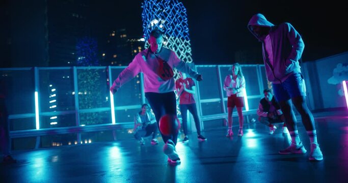 Talented Soccer Sportsman Performing Freestyle Tricks with a Ball. Footballer Showing Off Juggling Skills. Urban City Spot with Neon Lights, Graffiti on Walls and Scenery with Skyscrapers at Night