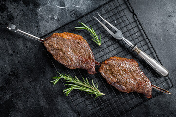 Picanha, traditional Brazilian barbecue, grilled beef meat steak. Black background. Top view