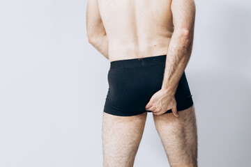 Beautiful male ass. The man is standing with his back to the camera. buttocks of a man in black...