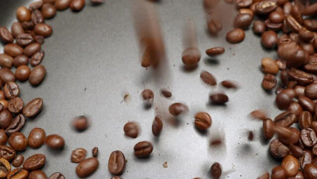 Kaffeebohnen fallen in Zeitlupe in einen Behälter 3
