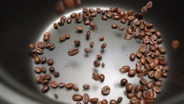 Kaffeebohnen fallen in Zeitlupe in einen Behälter 4