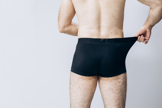 Beautiful male ass. The man is standing with his back to the camera. buttocks of a man in black shorts