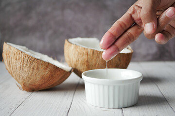 slice of fresh coconut and bottle of oil on a table 