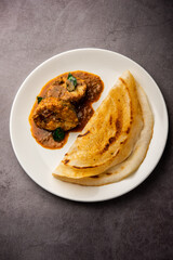 dosa with with fish curry from south Indian non vegetarian cuisine served in a plate