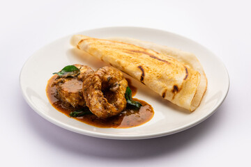 dosa with with fish curry from south Indian non vegetarian cuisine served in a plate