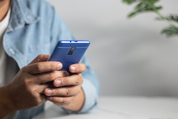 Men's hands on the table use mobile phones, technology, communications, the Internet.