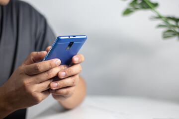 Men's hands on the table use mobile phones, technology, communications, the Internet.