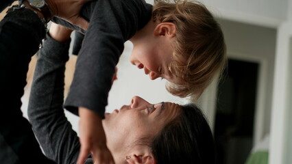 Toddler jumping in mother arms, parent lifting two year old baby in air