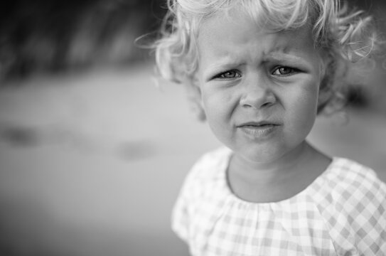 Close-up Portrait of a child with a sad look at the camera in black and white toning.