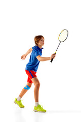 Obraz na płótnie Canvas Portrait of teen boy in uniform playing badminton, training, posing with racket isolated over white background. Winner
