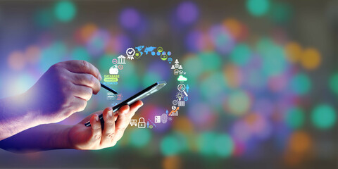Fototapeta man using stylus pen working on mobile phone with futuristic element digital icon on multi color blur background obraz