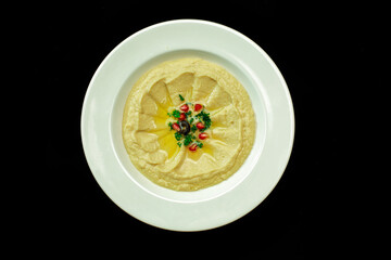 Bowl of homemade hummus isolated background from top view