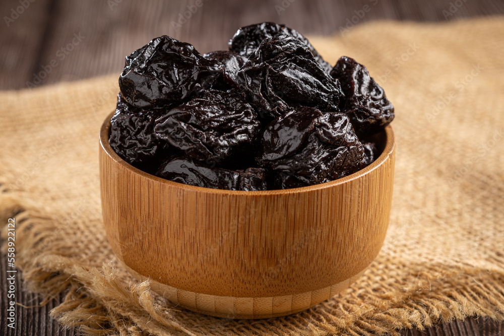 Wall mural Bowl with prunes on the table.