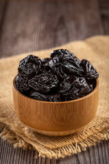 Bowl with prunes on the table.