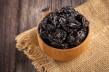 Bowl with prunes on the table.