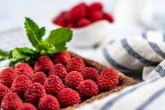 Raspberry Tart On Chocolate Puff Pastry Garnished With Mint Leaves
.