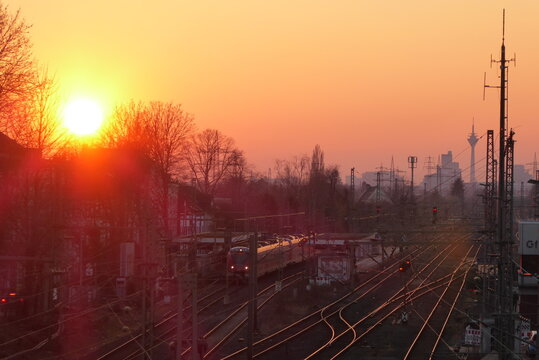 Sunset at Dusseldorf Gerresheim train station with a train and the skyline in Germany