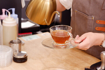 Coffee shop staff pouring tea into cups.