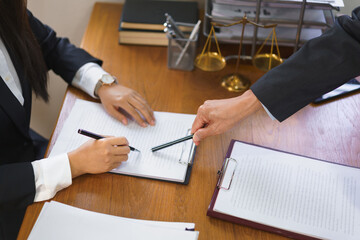 Legal and justice concept, Senior lawyer points on contract to provide law advice to female lawyer