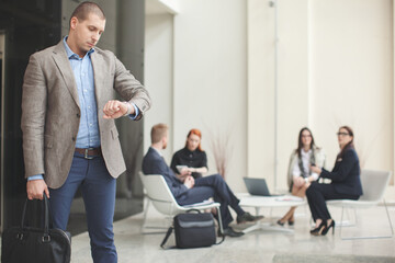 Fototapeta premium Businessman looking at watch while waiting for meeting