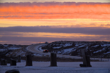 A red sunset over snow covered road by the Gulfoss falls in Iceland