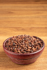 Bowl with cocoa nibs on the table.