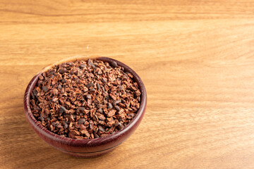 Bowl with cocoa nibs on the table.