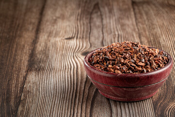 Bowl with cocoa nibs on the table.