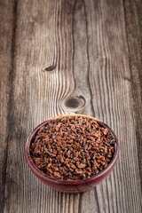 Bowl with cocoa nibs on the table.