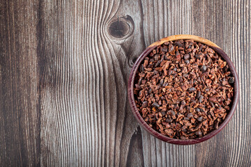 Bowl with cocoa nibs on the table.