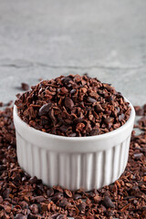 Bowl with cocoa nibs on the table.