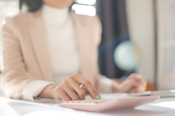 Close-up photo of woman hands doing calculating Bill with calculator financial planning and checking receipts at home office