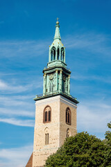 Obraz premium Top of the clock tower of the medieval Marienkirche ( St. Mary's Church ) in Berlin, Germany.