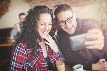 A couple in love are enjoying themselves in the cafe drinking coffee