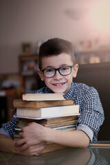 A very cute boy is studying and writing his homework