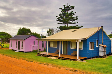 Fototapeta na wymiar Blue wooden cottage and tiny pink church in a village in Western Australia 
