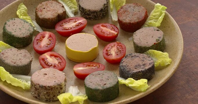 Selection of pates decorated with tomatoes and lettuce leaves on a plate. Table spin.