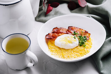 breakfast barley porridge with bacon and a poached egg