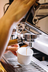 Professional coffee machine with white cup and pouring drink