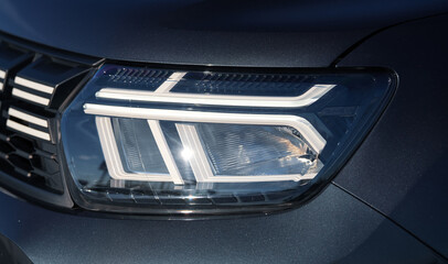 LED front light of a new Dacia Duster car. Detail view of the headlight. Romania, 2023.