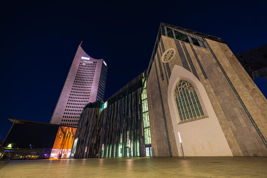 Leipzig, Germany - July 02, 2022: The new Paulinum of the University of Leipzig, stands at the site of the old university church. Behind it the city Hochhaus (city skyscraper). At night at Leipzig
