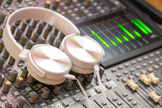 white headphone on audio mixing console. music background or recording concept