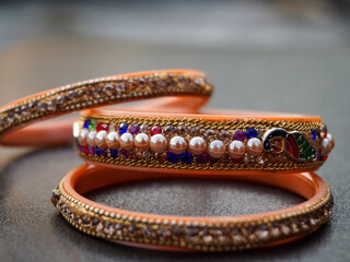 Indian bangles in orange color with colorful stones on it