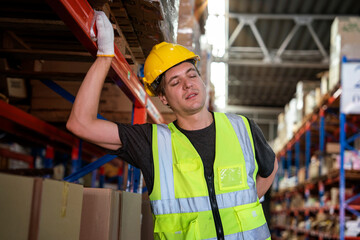 Male skin worker wearing reflective safety vest and helmet working in warehouse delivering goods...