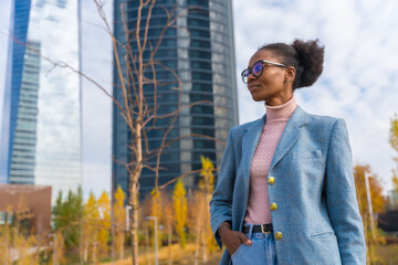 Portrait of black ethnic businesswoman wearing glasses in business park, looking left