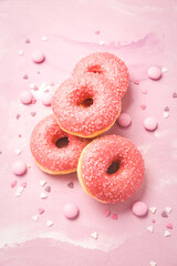 Pink donuts with sprinkles on pink background