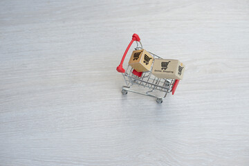 The shopping cart has a product box. Online shopping concept.