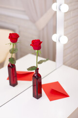 Red rose and envelope with copy space, on table in beauty salon. Valentine's day background, love and romance.