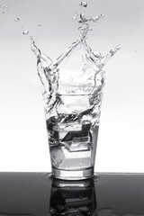  ice water splashing out of glass.